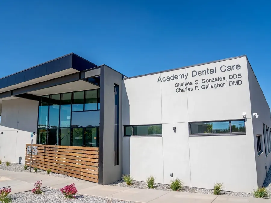 The Academy Dental Care building at 6425 Holly Ave NE, under a clear blue sky.